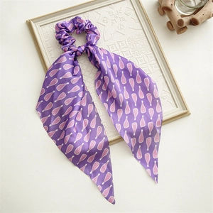 Detailed view of periwinkle blue silk scrunchie with pink floral bottle print ribbons