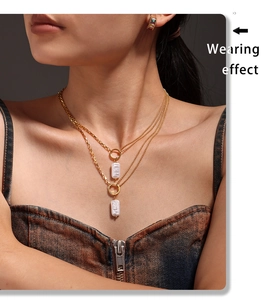 Detail of double-layer gold plated stainless steel necklace with baroque pearl pendant
