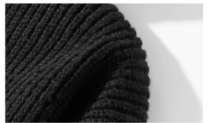 Detailed macro view of the black ribbed knit fabric texture of the oversized hoodie