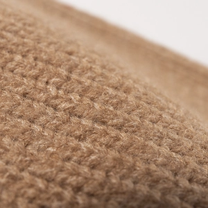 Close-up of stylish camel knit beanie featuring thick textured weave for winter warmth