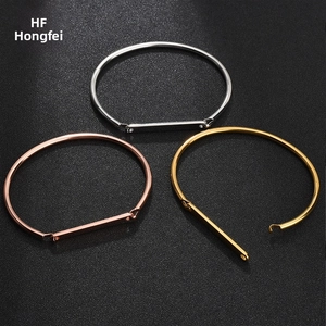 Three minimalist stainless steel bangles in silver, gold, and rose gold with polished bar