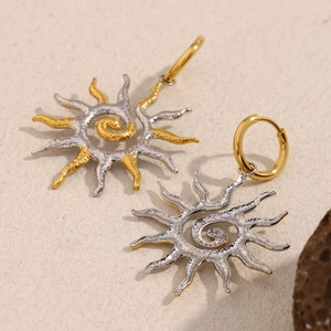 Détail des boucles d'oreilles soleil en plaqué or 18 carats avec texture martelée et spirale