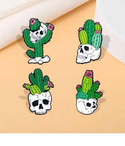 Detailed macro of four punk enamel pins featuring cactus skull and floral designs