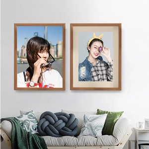 Minimalist wooden specimen frames displayed vertically on a white wall in a cozy living room