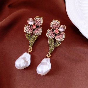Gros plan de boucles d'oreilles fleur vintage avec strass et perles baroques