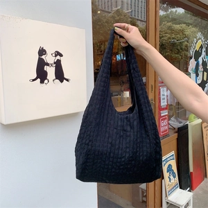 Detail shot of the black textured bubble fabric on a large capacity canvas tote bag