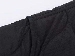 Detail of black quilted fabric with fine square texture and high-quality stitching