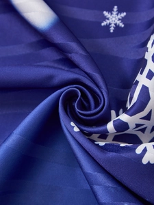 Detail of blue Christmas fabric with snowflake print showing soft drape and fine texture