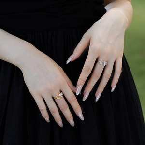 Close-up of gold and silver S925 sterling silver heart rings with zircon on model hands