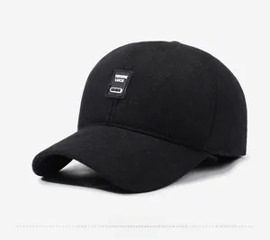 Detail of a black wool winter baseball cap showing the stitched brand patch and fabric texture