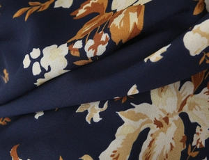 Macro detail of navy floral printed crepe fabric showing vintage pattern and soft texture