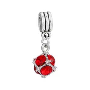 Detailed view of a silver alloy charm pendant with faceted red crystal and 3-ring clasp