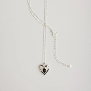 Detail of 925 silver heart necklace featuring a polished black teardrop gemstone center