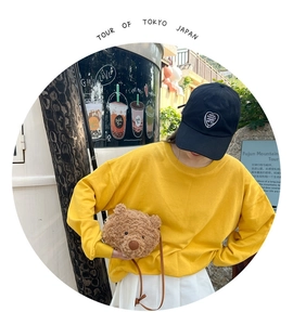 Close-up of cute plush bear head crossbody bag paired with a yellow casual sweatshirt