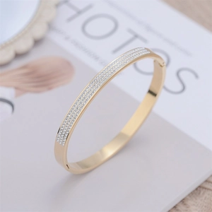 Close-up of gold-plated bracelet featuring three rows of sparkling pave set diamonds