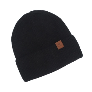 Close-up of black knitted beanie with a premium brown leather brand label detail