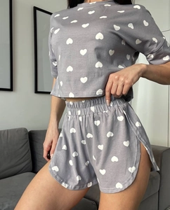 Close-up of gray short-sleeved pajama set with white heart prints and drawstring waist
