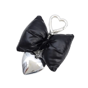 Chic black padded faux leather bow keychain with polished silver heart pendant