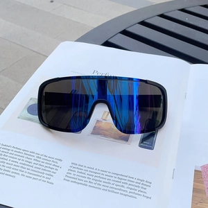Detail of sports sunglasses with blue mirrored lenses and matte black frame on a magazine