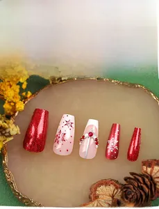Detailed view of Christmas press-on nails with red glitter, snowflake art, and rhinestones