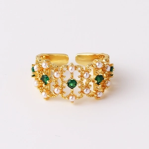 Detail of vintage gold open ring with green zircon stones and white pearls