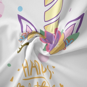 Close-up detail of soft white fabric with colorful unicorn and floral cartoon print