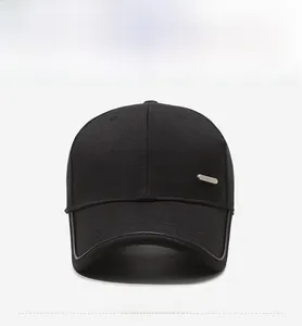Close-up of black cotton baseball cap with grey brim trim and silver metal plaque detail