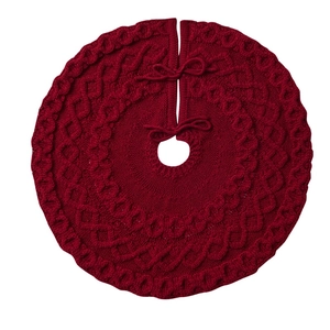 Détails de la jupe de sapin de Noël rouge tricotée avec des motifs de torsades