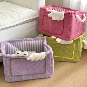 Detail of plush monster storage baskets with cloud decor and striped lining interior