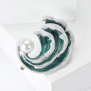 Détail de la broche en émail en forme de vague avec glaçure cyan et une perle blanche