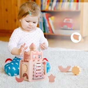 Toddler playing with 5-in-1 pink wooden castle toy featuring xylophone and shape sorter