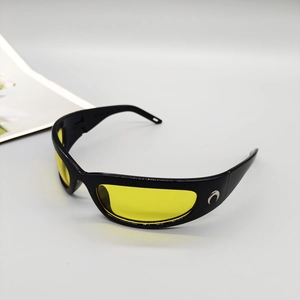 Detail of streamlined sports sunglasses with yellow lenses and metallic crescent logo