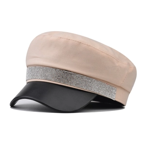 Detail of beige cotton newsboy cap with black faux leather brim and sparkly rhinestone band