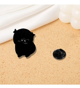 Detail view of the black metal frog enamel pin back with secure rubber clutch backing
