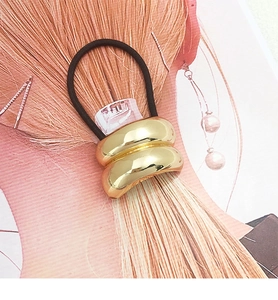 Macro shot of polished gold U-shaped metal cuff ponytail holder with high elastic band