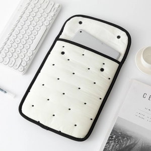 Detailed view of quilted polka dot tablet sleeve with black binding and snap closure