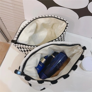 Gros plan sur des trousses à maquillage en tricot à pois noirs et blancs avec fermeture