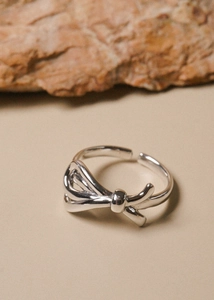 Macro shot of 925 sterling silver bow ring with adjustable band and polished finish