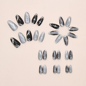 Detail view of almond nails with black cat eye finish and silver starburst patterns