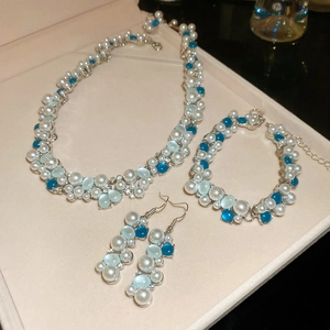 Detailed jewelry set with pearl necklace, bracelet and earrings in a gift box