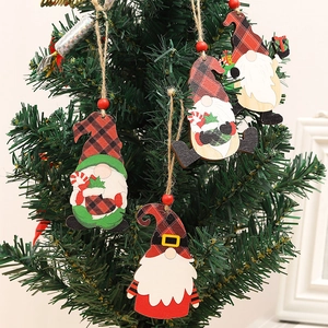 Set mit vier hölzernen Weihnachtsgnom-Anhängern, die an einem Weihnachtsbaum hängen