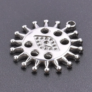 Macro detail of silver sun eye pendant with sparkling crystals and metal cutouts