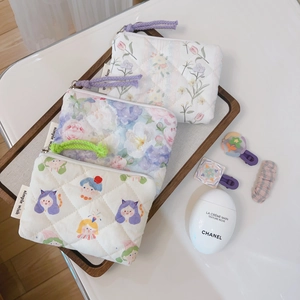 Detail view of quilted cotton mini pouches with floral patterns and colorful lanyards