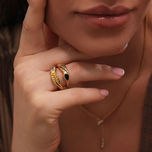 Macro shot of gold snake ring featuring scales texture and sparkling zircon stones