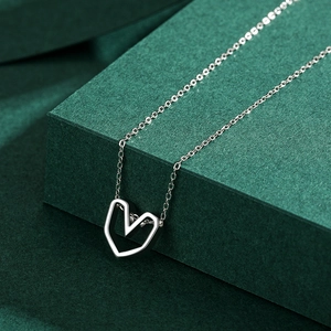 S925 sterling silver minimalist heart pendant necklace on textured green display stand