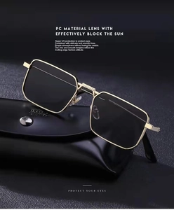 Detail of luxury gold metal square sunglasses with black lenses and leather case