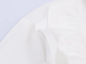 Detail shot of white poplin shirt showing ruffle edges and textured fabric pleats