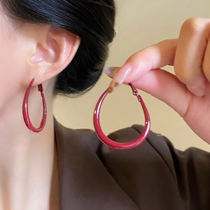 Elegant deep red teardrop hoop earrings for women with high gloss finish on model