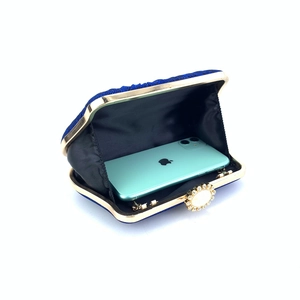 Macro shot of navy blue evening clutch interior showing space for smartphone and hardware