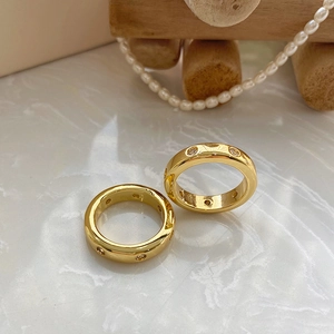 Vista detallada del anillo de latón chapado en oro con circonitas sobre mármol